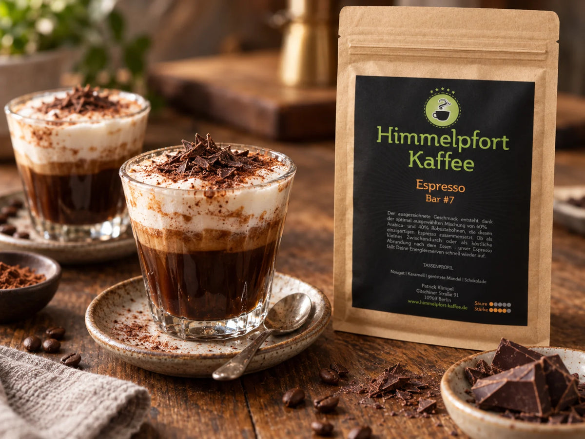 Caffè Marocchino mit Espresso Bar #7, kräftigem Espresso, cremigem Milchschaum, Kakao und dunklen Schokoladenraspeln, daneben die originale Himmelpfort-Kaffee-Tüte Espresso Bar #7